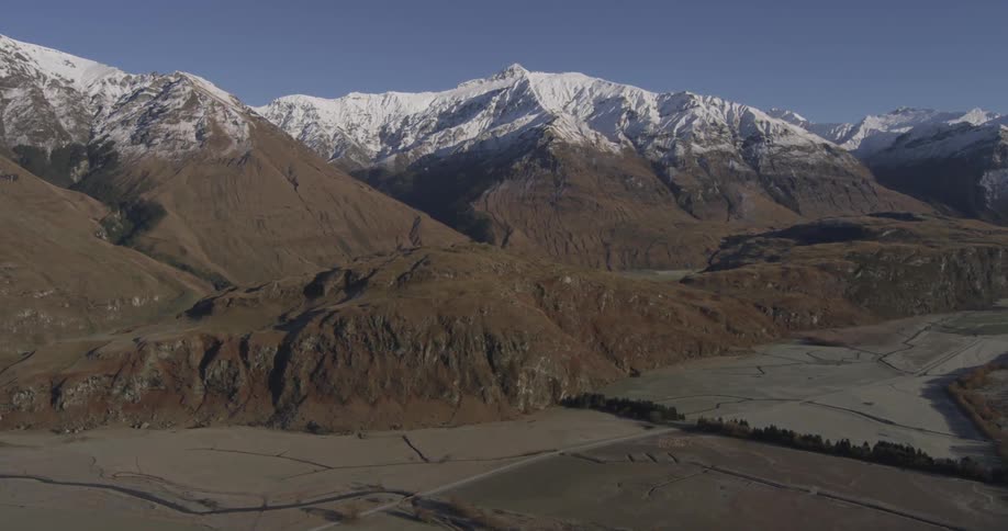 Snow capped mountains on a barren terrain