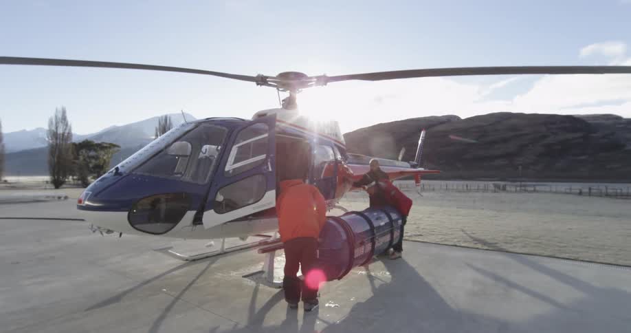 A group of people are loading a helicopter