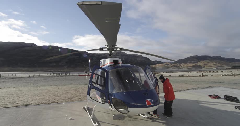 People standing beside a landed helicopter