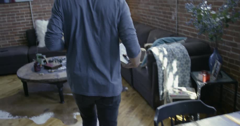 Man picks up a book from a dining table