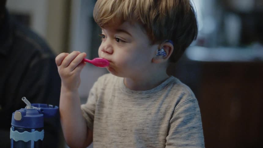 Young boy eats food from a bowl