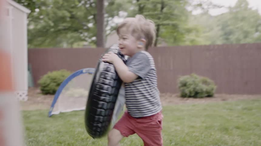A group of young kids are throwing inflatable tires at each other
