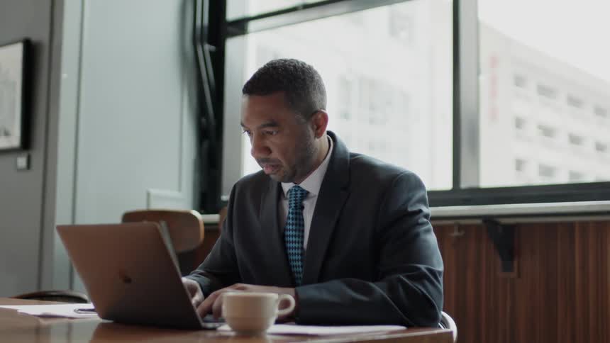 Businessman types on a laptop in an office