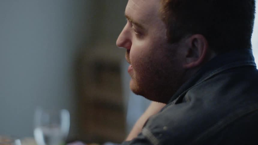 Man is sitting at dinner table and talking