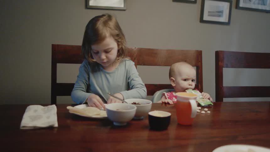 Two children eat at the table
