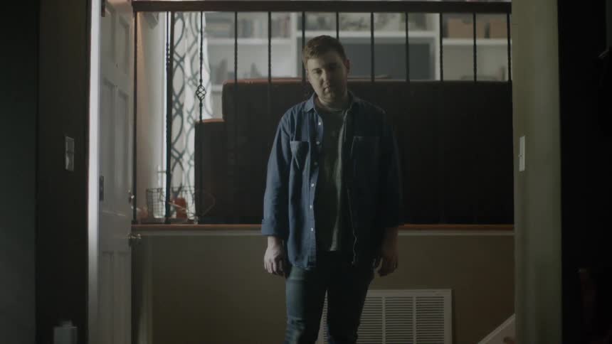 Man stares at the floor inside a house