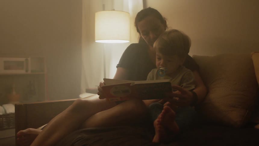Mother and son read a book at home