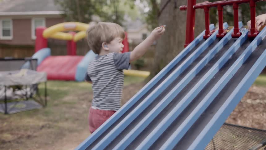 A young boy plays in a backyard