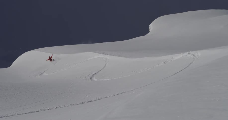Snowboarder going downs snowy mountain