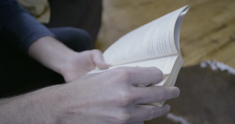 Two hands hold a book open
