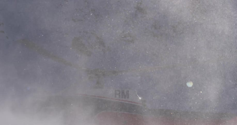 Close up of a helicopter and snow swirling around