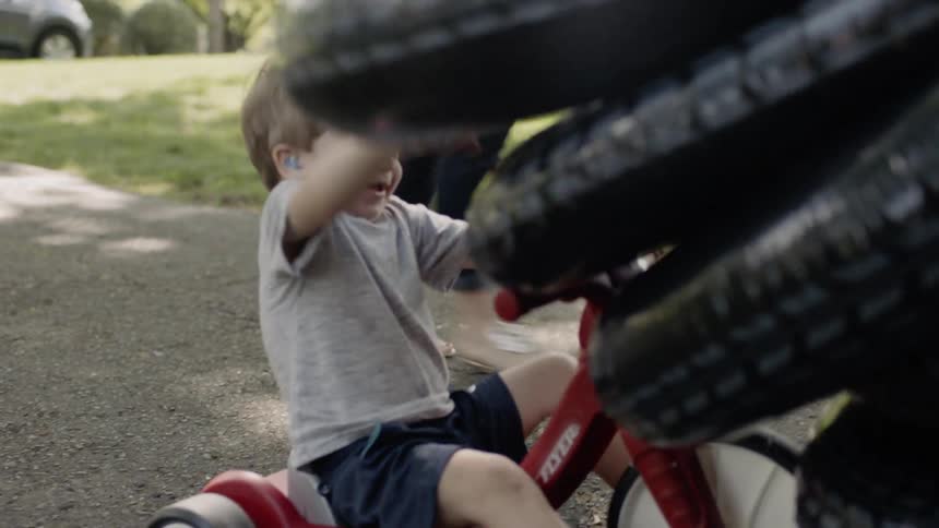Toddler boy rides a tricycle