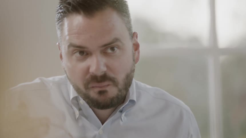 Bearded man puts a spoonful of food in his mouth