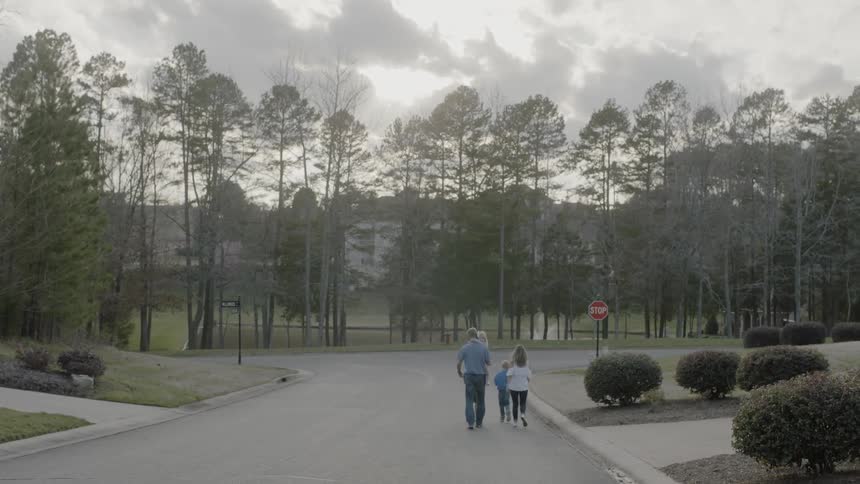 A family walks on a residential street