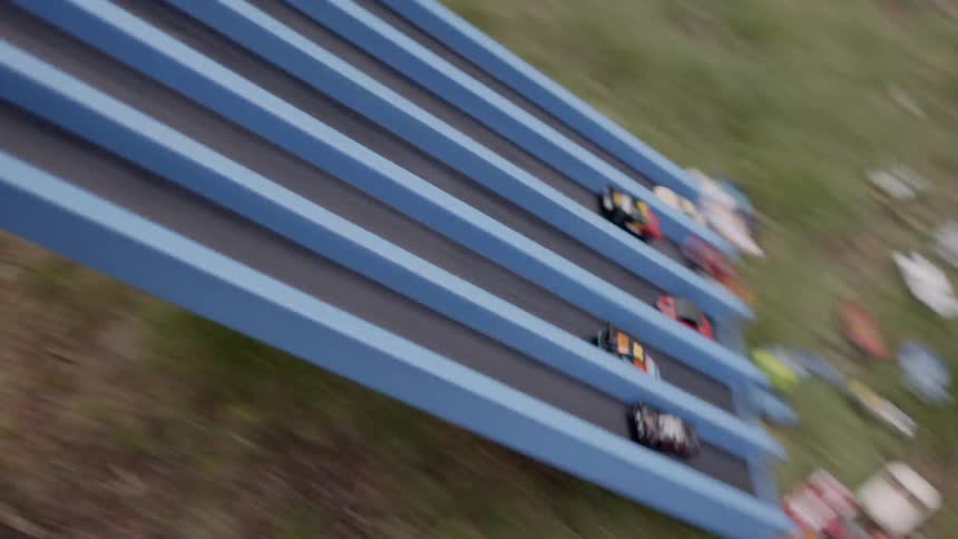 Children release tiny cars down a slide
