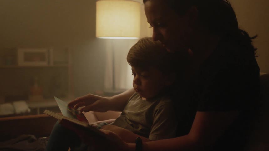 Mother and son read a book at home