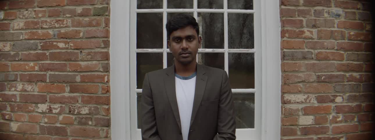 A man waits nervously by a window