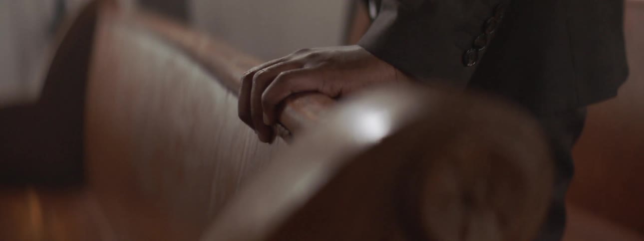 Person holds onto a brown bench