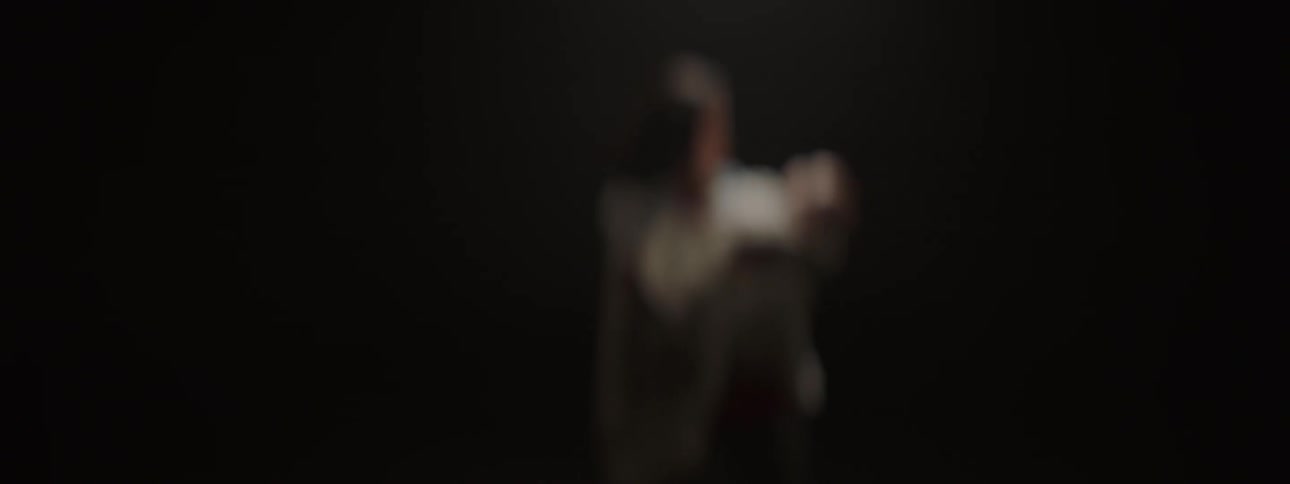 A blurry view of a woman rocking a baby