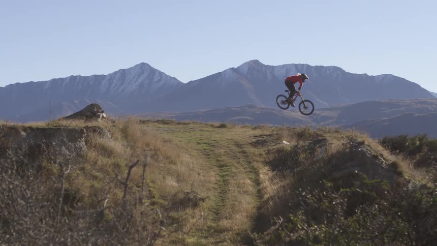 Person riding a bmx bike does a huge jump over the dirt