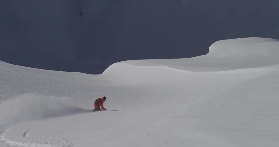 A snowboarder going downhill