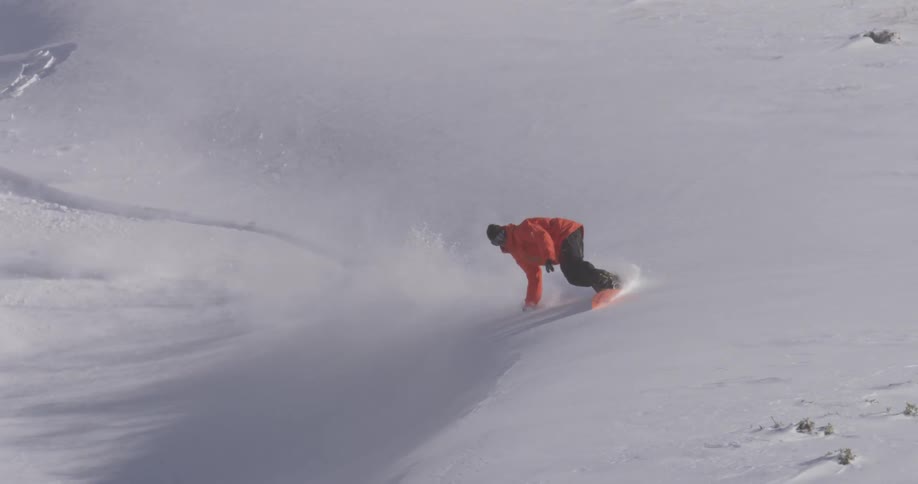 A snowboarder doing a jump on the mountain