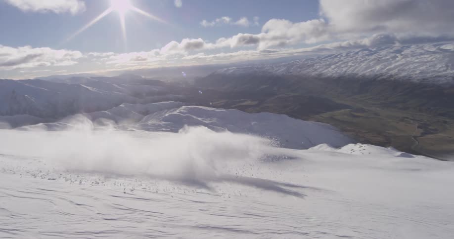 Snowboarder swiftly going down a large mountain
