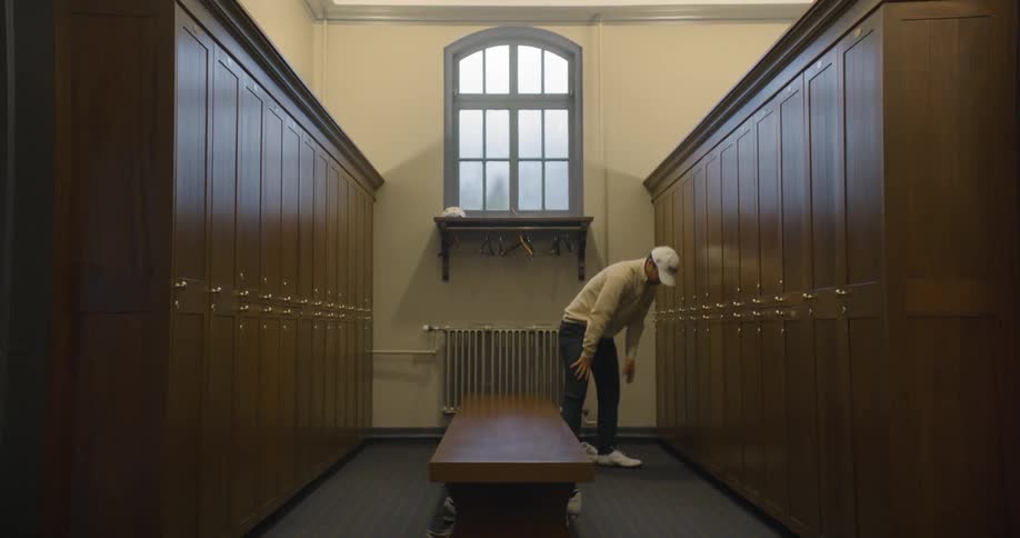 Golfer ties his shoes in locker room