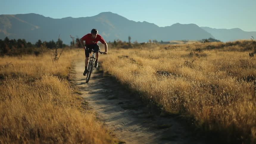 A man is riding a mountain bike around a dirt curve