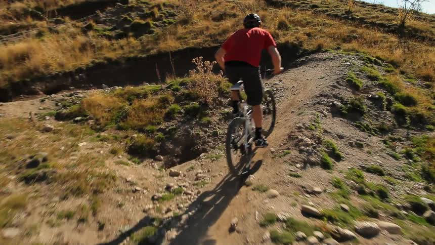 Man riding his bike fast down a dirt path