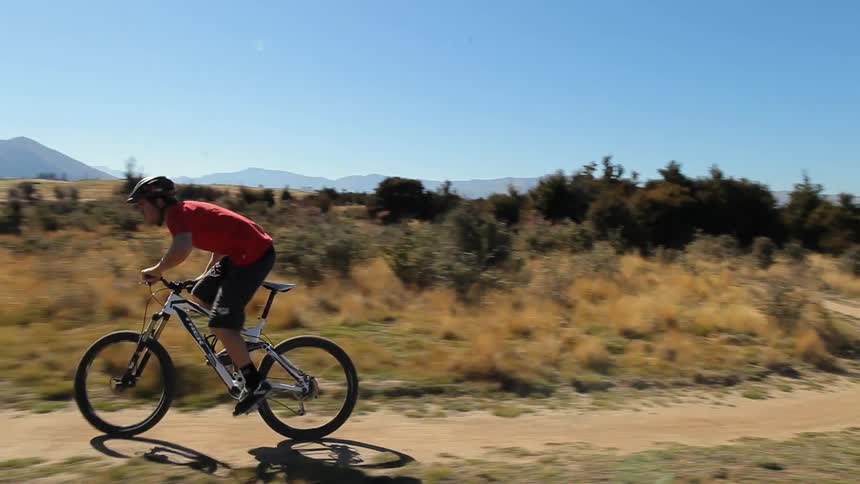 Man mountain biking down a path