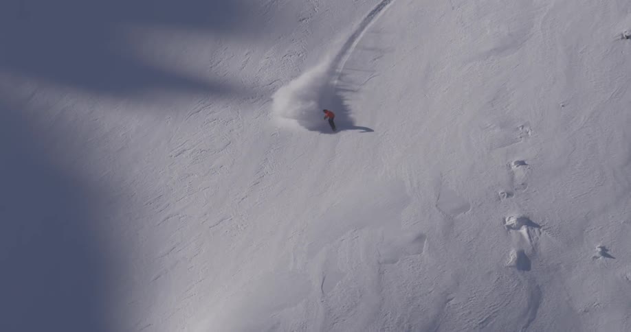 A snowboarder rides down a mountain