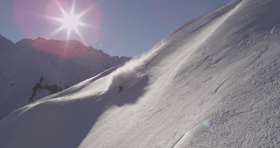 Person snowboarding down a very steep snow hill