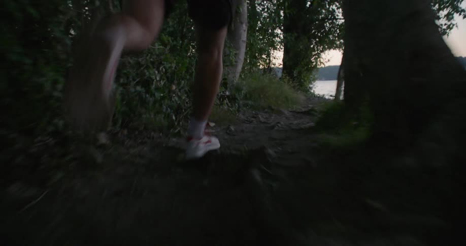A man jogs uphill over a trail towards the water
