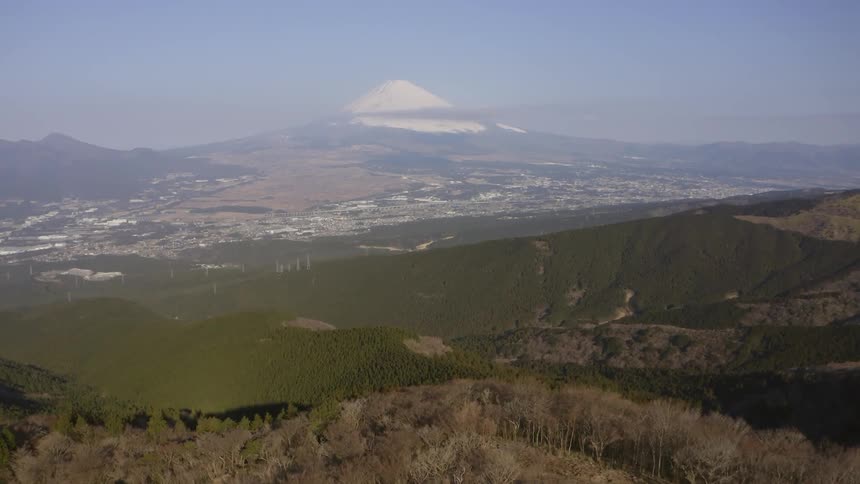 The large valley leads to a town at the bottom of the hills