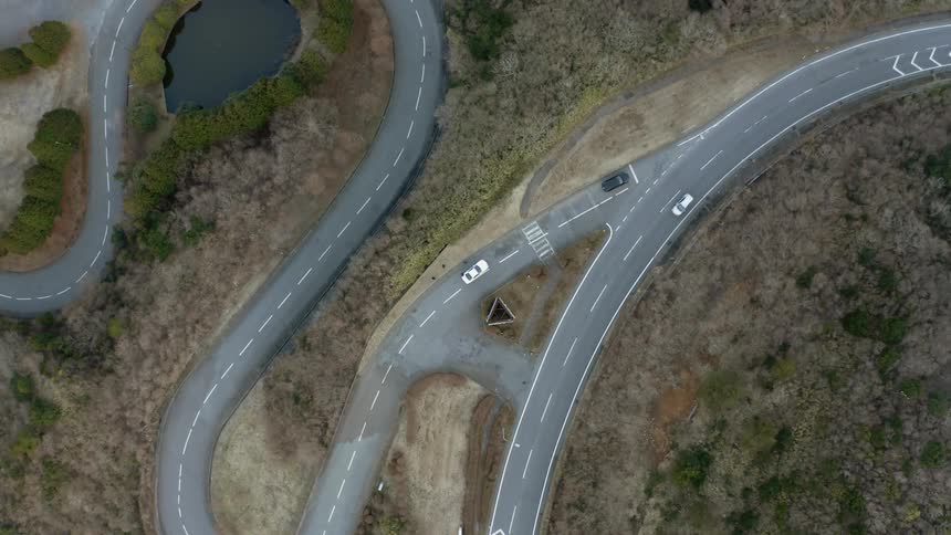 Two vehicles stopped on a winding road