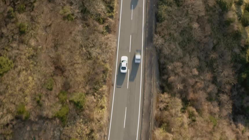 The white car turns around the winding road