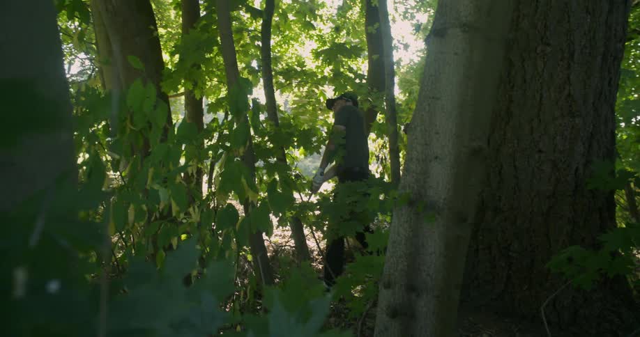 Golfer hits a golf ball while in a forest