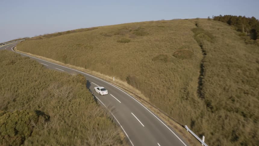 Car drives on a winding country road