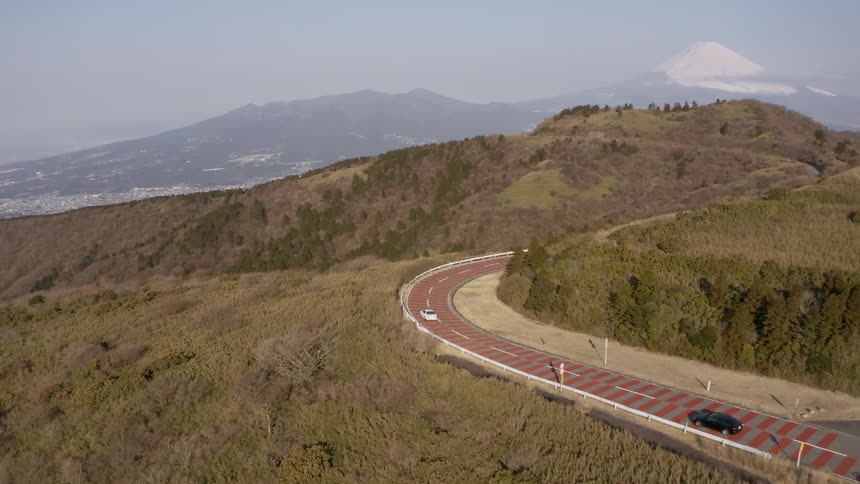 Vehicles drive on a winding mountain road