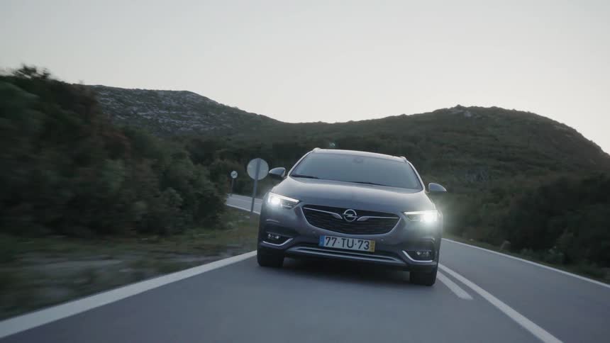 Car drives down a country road in the evening