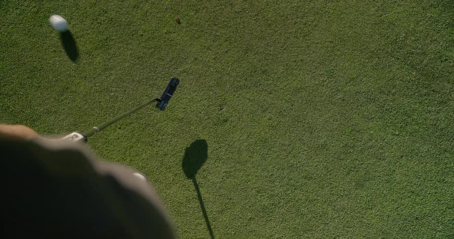 Person hits a golf ball with a club