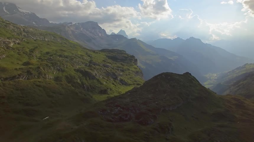 Clouds are drifting over a mountain range in daylight