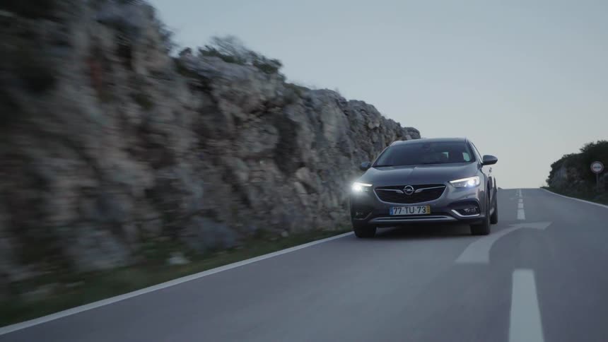 Car drives down a country road in the evening