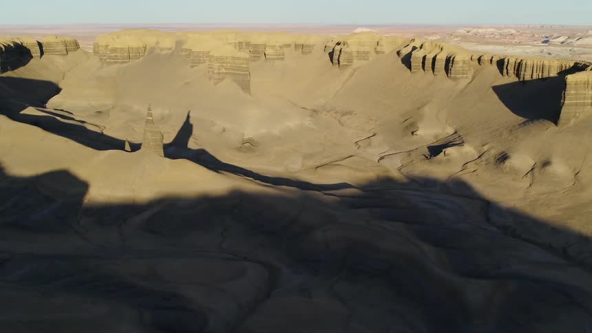 Shadows fall over hilly desert landscape on a sunny day