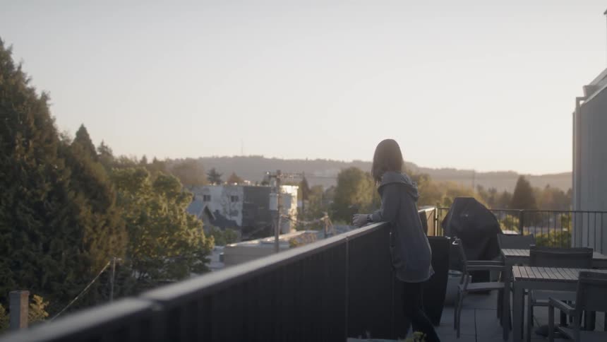 A woman leans on a deck railing