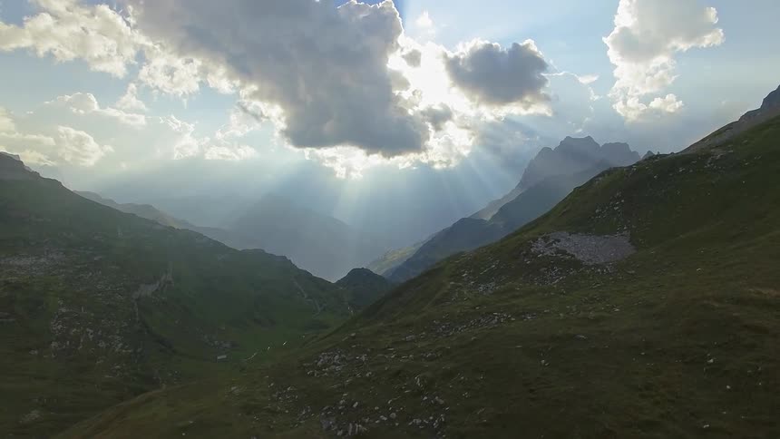 Sun shines through clouds over mountains
