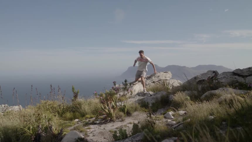 A man jumps over the rocks on the hill