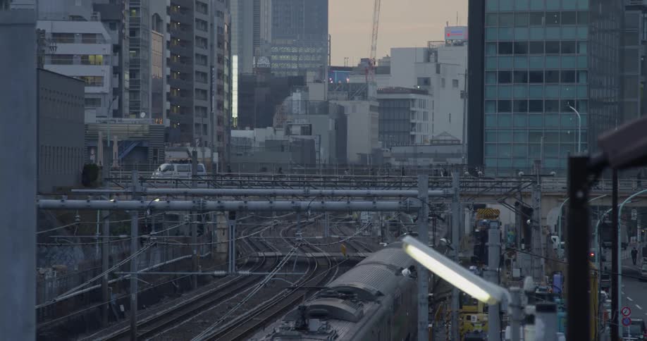 Traffic travels over a bridge in a city as train travels under it