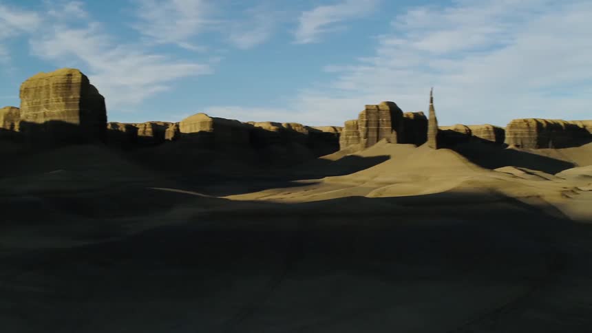 Shadows over a hilly desert landscape